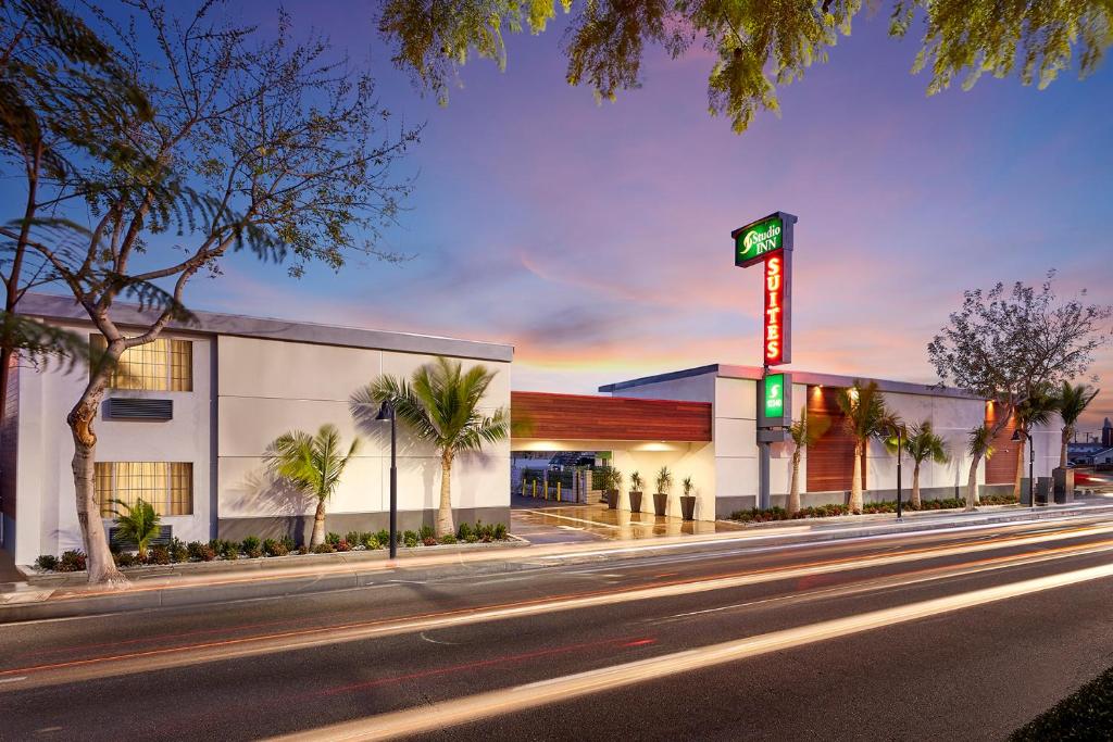 un edificio con un letrero al lado de una calle en Studio Inn & Suites at Promenade Downey, en Downey