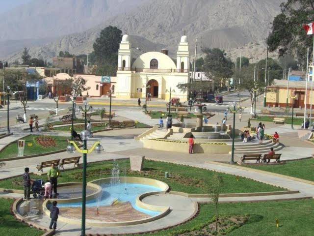 un grupo de personas caminando por un parque con una iglesia en Hotel Elizabeth Hoss, en Sayán