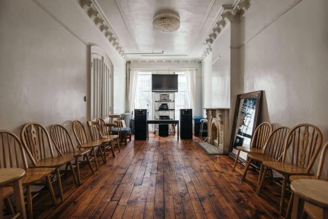 um quarto vazio com mesas e cadeiras de madeira num quarto em Illumination Bed & Breakfast em Brooklyn