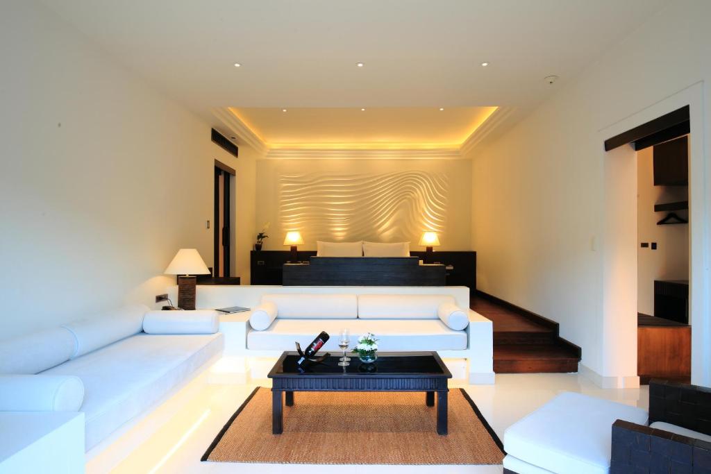 a living room with a white couch and a table at The Racha in Ko Racha Yai 