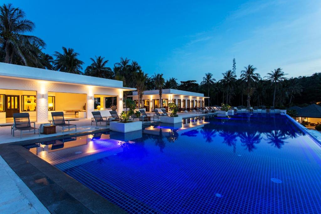a swimming pool in front of a house at night at The Racha in Ko Racha Yai 