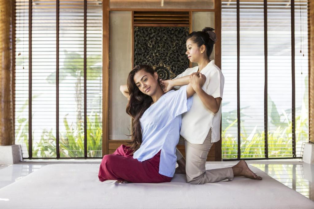 a woman sitting on the floor cutting a girls hair at The Racha in Ko Racha Yai 
