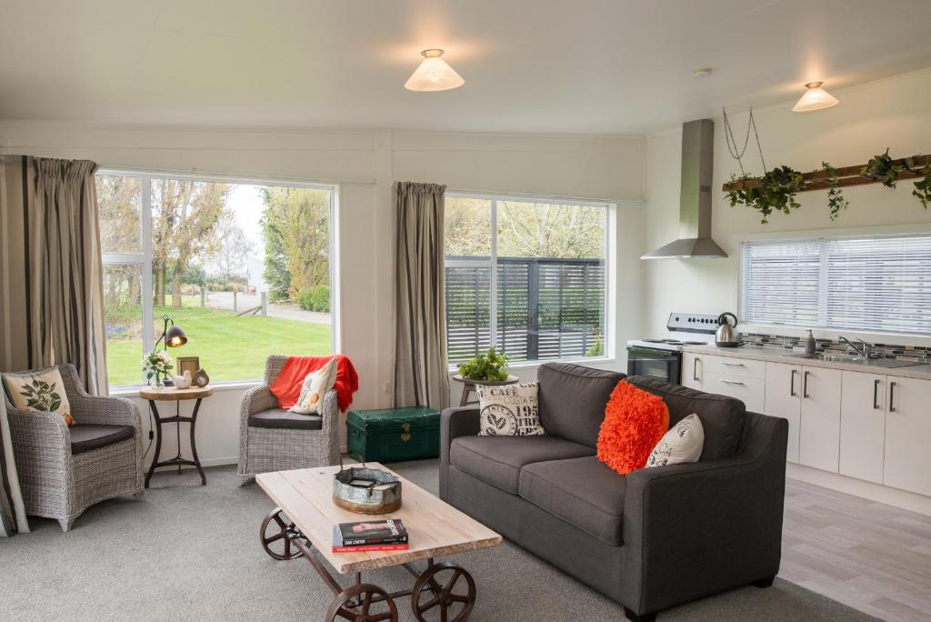 a living room with a couch and a table at Thistle Cottage in Ashburton