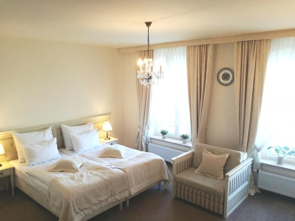 1 dormitorio con 2 camas y lámpara de araña en Hotel SPA Akacjowy Dwór, en Stargard