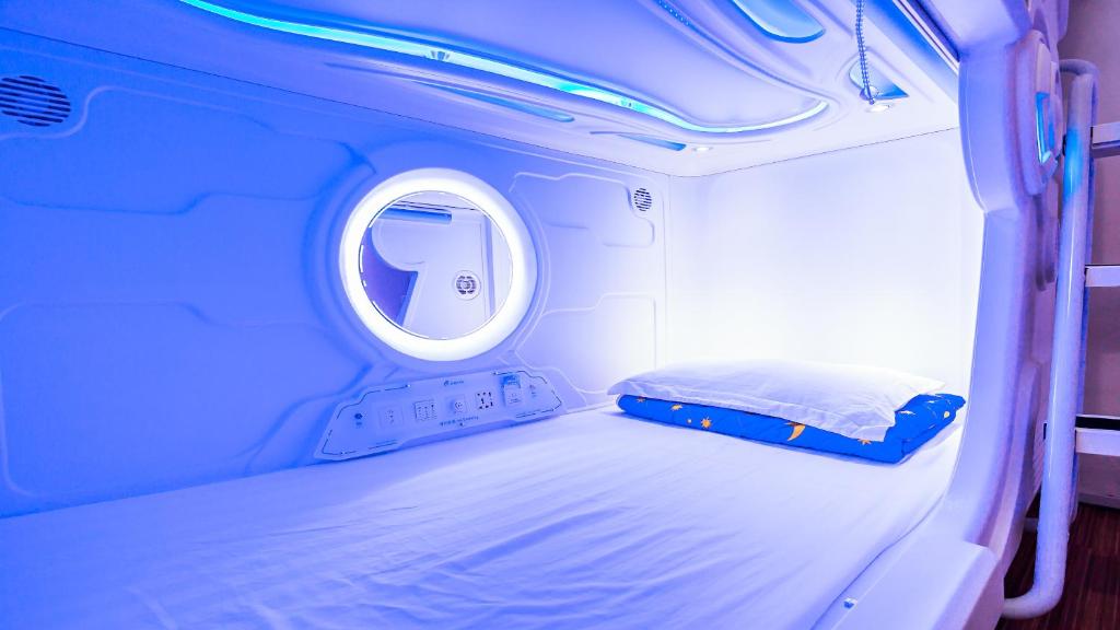 a small room with a bed and a mirror at Spacepod@SG in Singapore