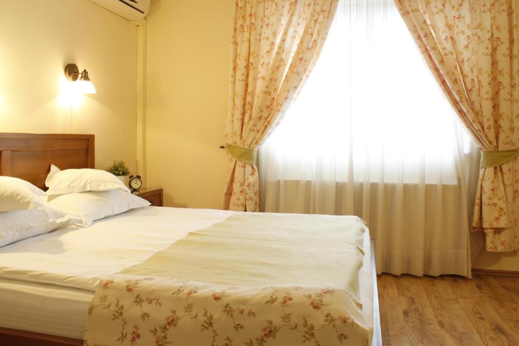 a bedroom with a large bed and a window at Vila Toparceanu Otopeni in Otopeni
