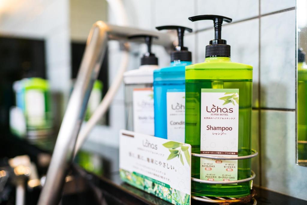 a shelf with three bottles of hair products on it at Super Hotel Okinawa Nago in Nago