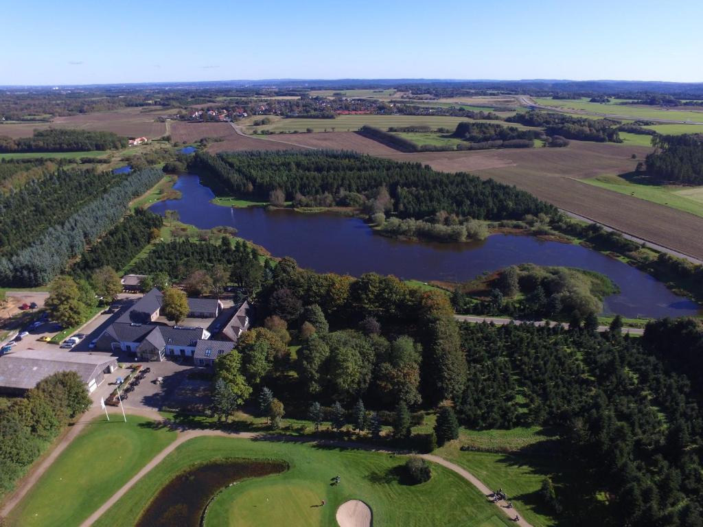 an aerial view of a house and a lake at Tollundgaard Golf Park & Apartments in Funder Kirkeby