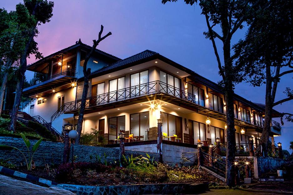 a large house with lights on it at night at Villa Sawah Resort Managed by Salak Hospitality in Bogor