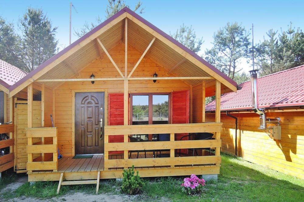 drewniany domek z drzwiami i ogrodzeniem w obiekcie Domki nad morzem - Wisełka w Wisełce
