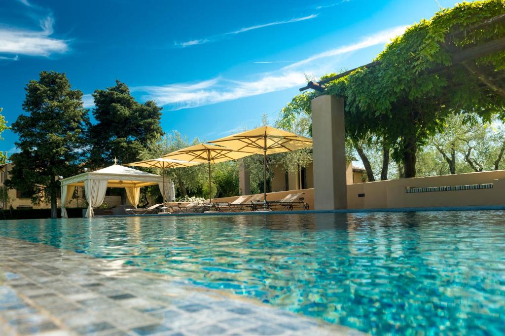 a swimming pool with umbrellas and a resort at Tenuta di Santa Lucia in Soriano nel Cimino