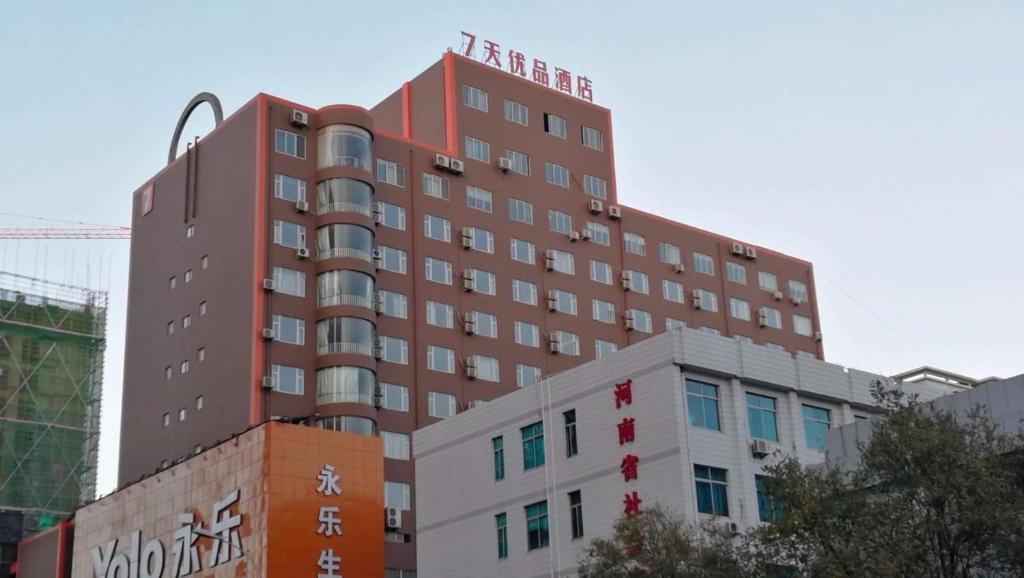 un edificio rojo alto con graffiti en 7Days Premium Zhengzhou Jingsan Road Century Lianhua en Zhengzhou