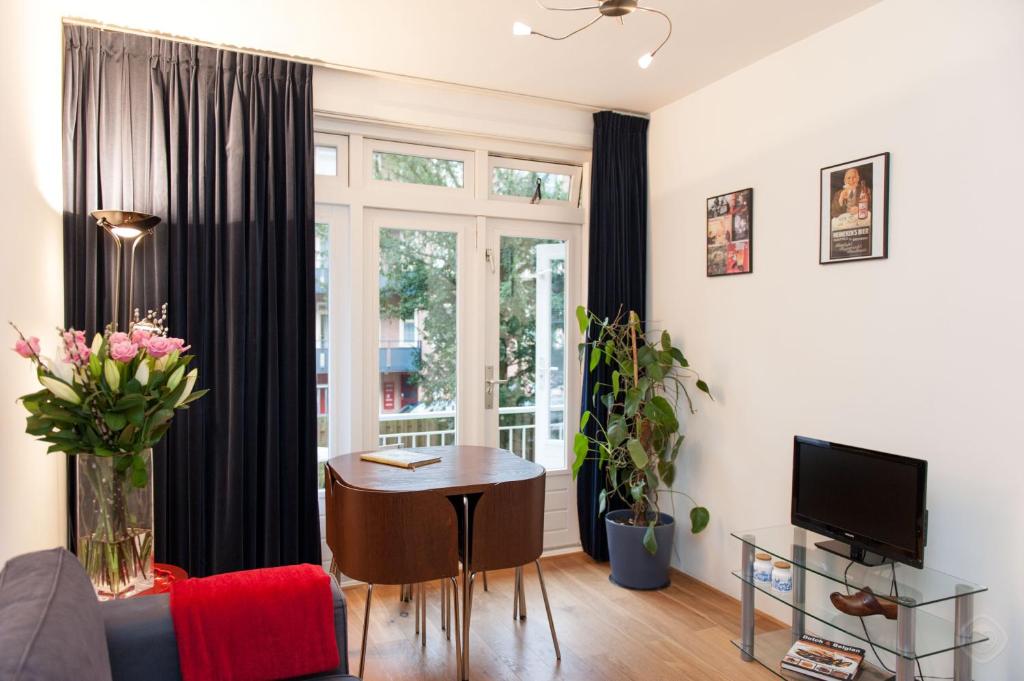 een woonkamer met een tafel en een raam bij B&B West City Amsterdam in Amsterdam