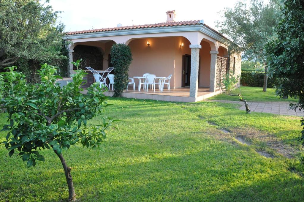 ein Haus mit einem Garten und einer Terrasse in der Unterkunft Case Vacanza Fenicotteri in San Teodoro