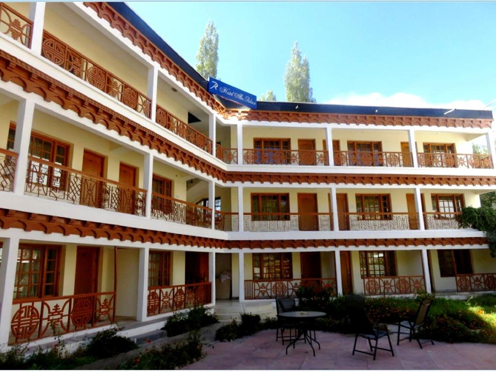 a building with tables and chairs in front of it at Hotel Abu Palace in Leh