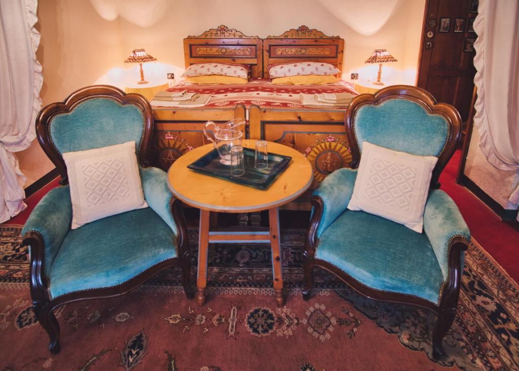 Ala di Stura的住宿－La Crestolina，一间卧室配有一张带桌子和两把椅子的床