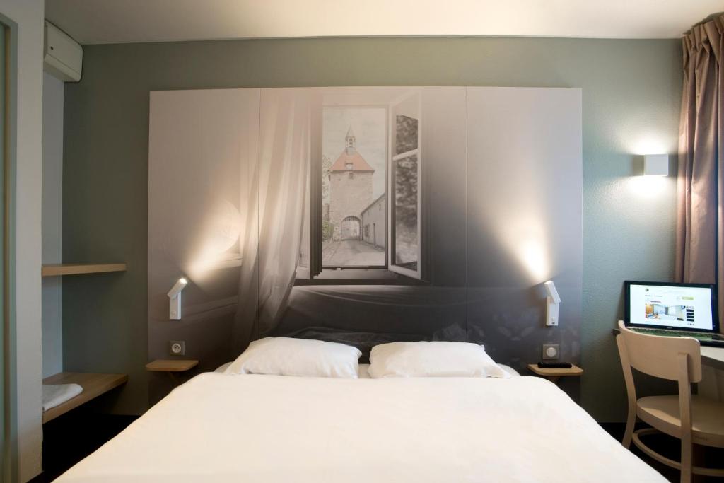 Un pat sau paturi într-o cameră la B&B HOTEL Moulins