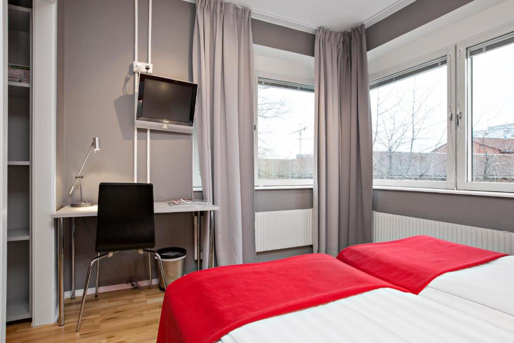 a bedroom with a bed and a desk with a computer at Sure Hotel by Best Western Stockholm Alvsjo in Stockholm