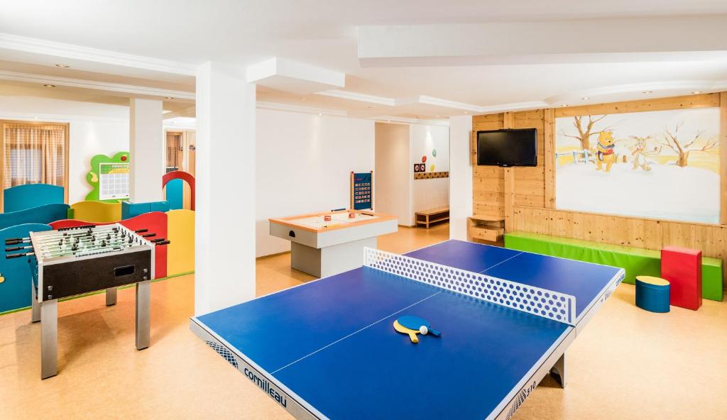 a childrens play room with a ping pong table at Hotel Alpenroyal - The Leading Hotels of the World in Selva di Val Gardena