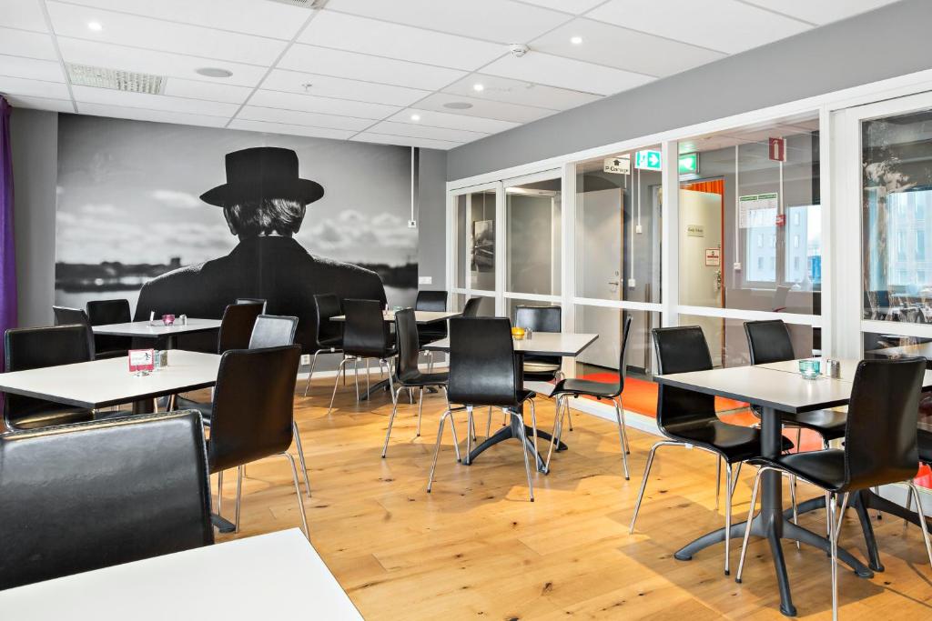 a dining room with tables and a man in a top hat at Sure Hotel by Best Western Stockholm Alvsjo in Stockholm