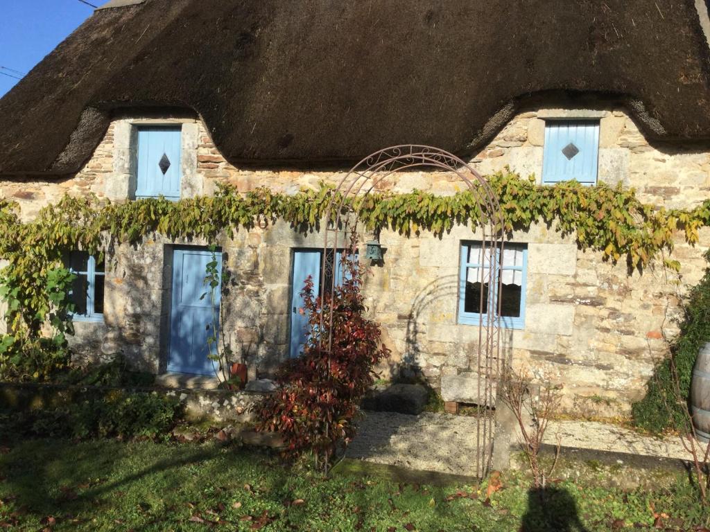 Cette ancienne maison en pierre est dotée d'un toit de chaume. dans l'établissement Cosquer Cottage, à Pluméliau