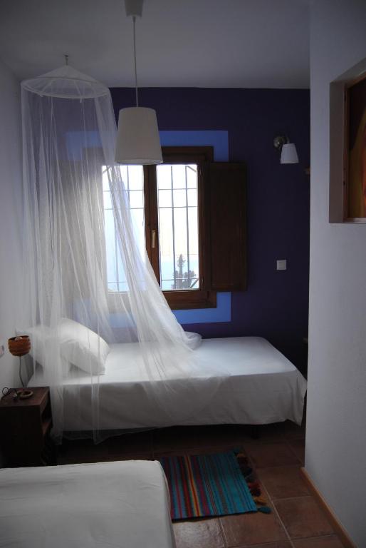 a bedroom with two beds and a window at Casa Entre Armonías in Zahara de los Atunes