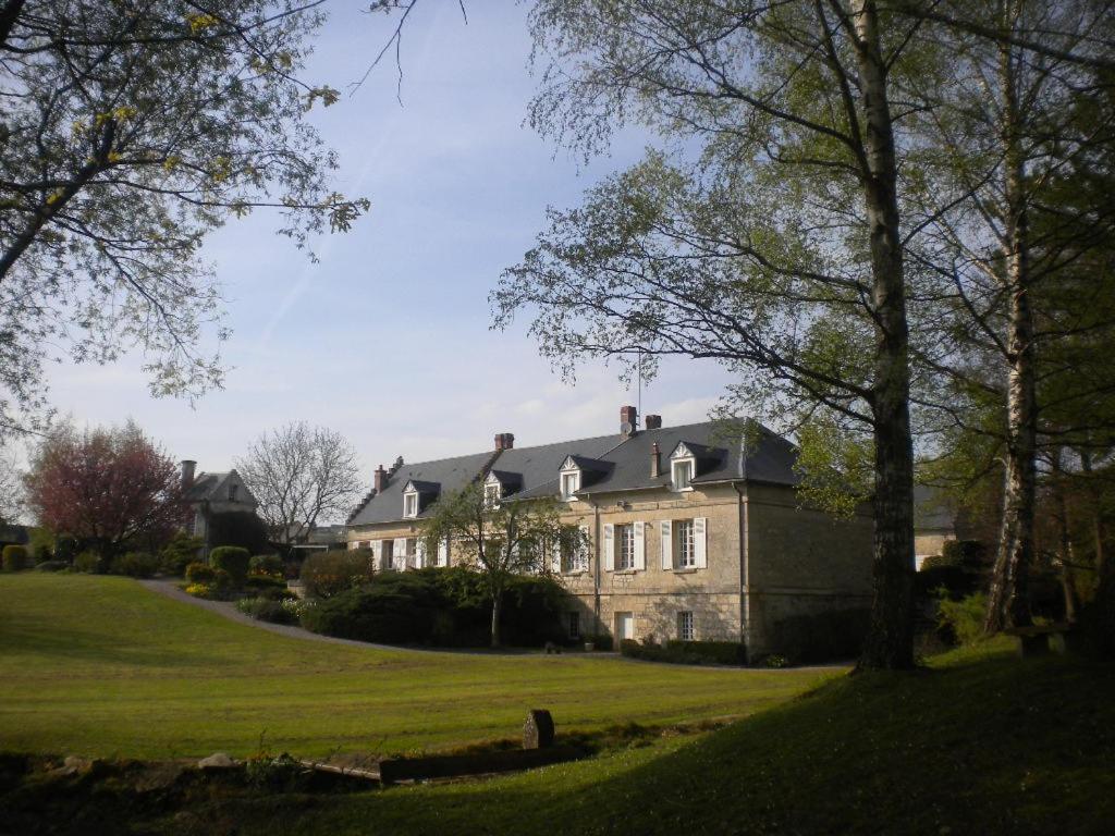 una casa grande en un campo verde con árboles en Le Moulin De Laval en Cuisy-en-Almont