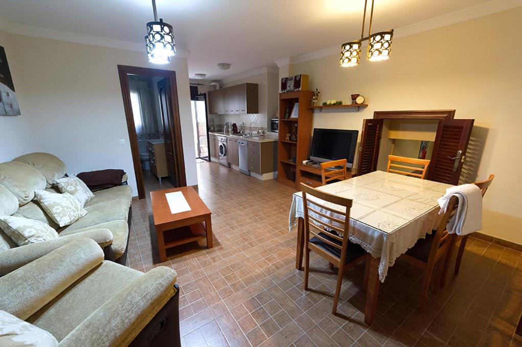 アンテケラにあるApartamento Antequeraのリビングルーム(ソファ、テーブル付)、キッチンが備わります。