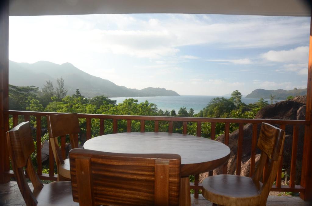 a table and chairs on a balcony with a view of the ocean at Mirella Villa Island Princess Villa in Praslin
