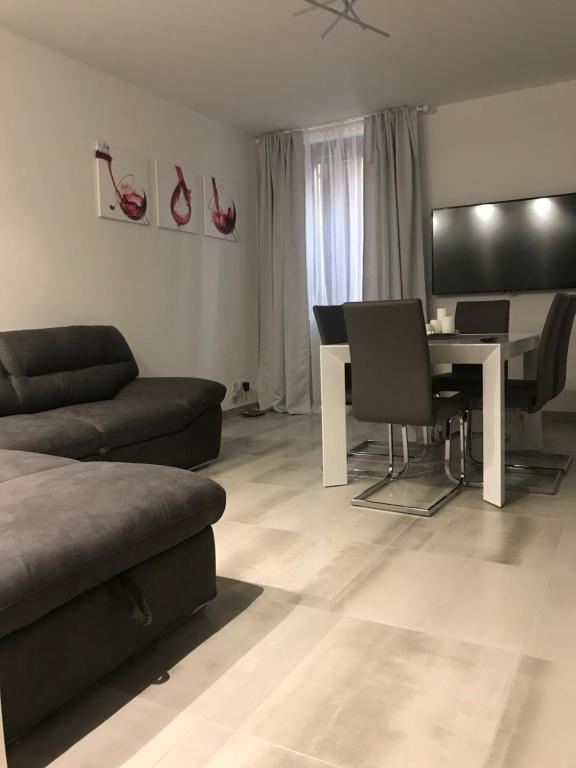 een woonkamer met een bank en een tafel met stoelen bij Loft Sirmione in Sirmione