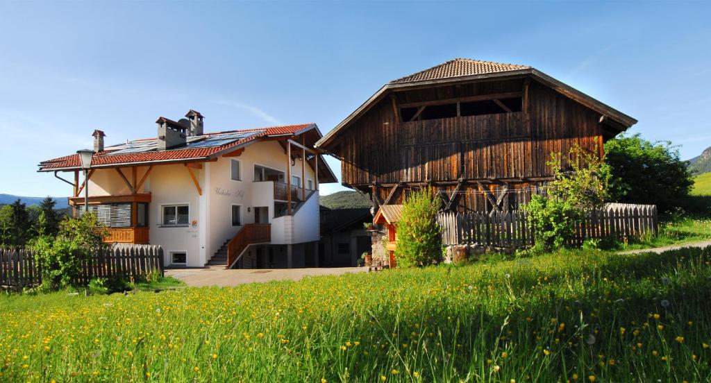 une maison dans un champ à côté d'un bâtiment dans l'établissement Urthalerhof, à Castelrotto