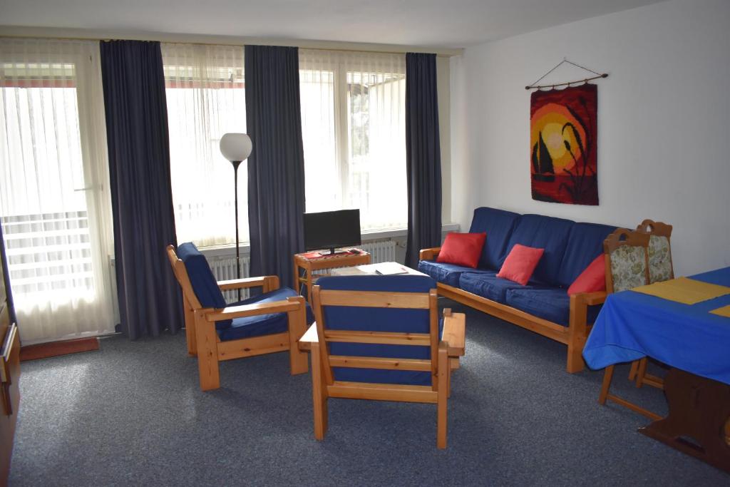 ダボスにあるFerienwohnung Bündawieseのリビングルーム(青いソファ、椅子付)