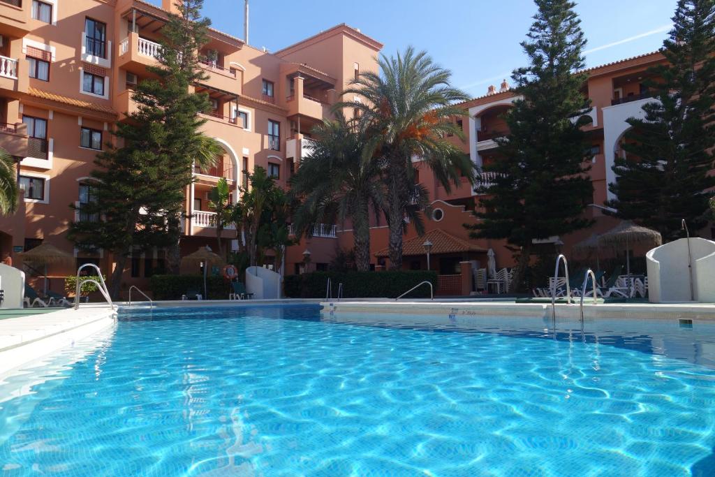 a swimming pool in front of a building at Apartamentos Estrella De Mar in Roquetas de Mar