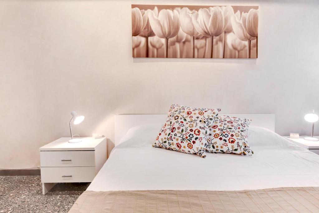a bedroom with a white bed with two pillows at Peggy Guggenheim Venice Apartment in Venice
