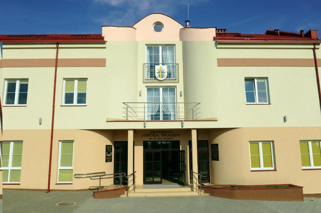 a large white building with a clock on it at Centrum Ostra Brama im. Jana Pawła II in Skarżysko-Kamienna