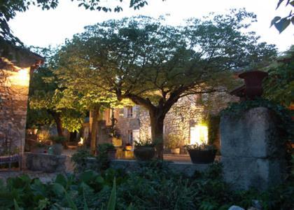 une cour avec un arbre et un bâtiment en briques dans l'établissement Mas Bella Cortis, à La Garde-Adhémar