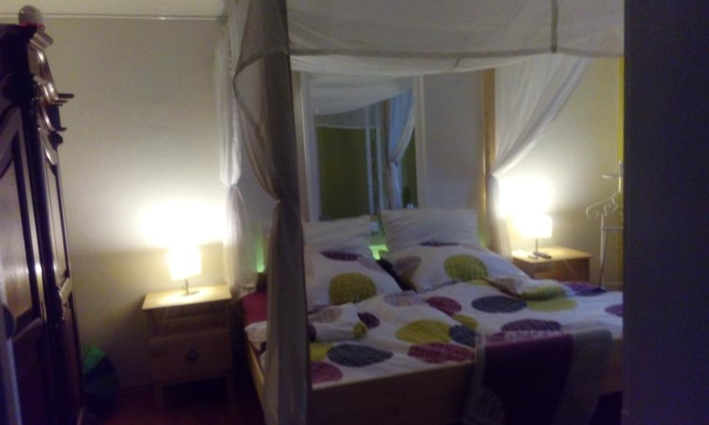 a bedroom with a canopy bed with two lamps at Privatzimmer Neu-Isenburg in Neu Isenburg