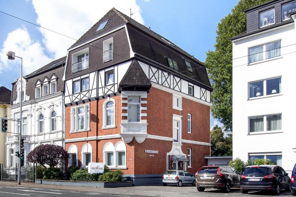 ein rotes Backsteingebäude mit schwarzem Dach in der Unterkunft Hotel Friederike in Mülheim an der Ruhr