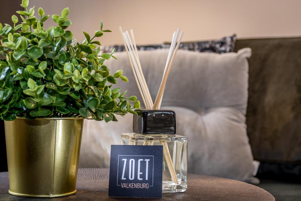 a table with a bottle of perfume and a potted plant at Zoet Valkenburg in Valkenburg