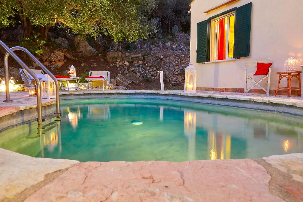 a swimming pool in a yard with a house at Villa Rosa Dei Venti - Scopello-Villas in Scopello