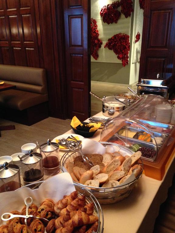 a buffet with many different types of bread and pastries at Le Windsor, Jungle Art Hotel in Nice