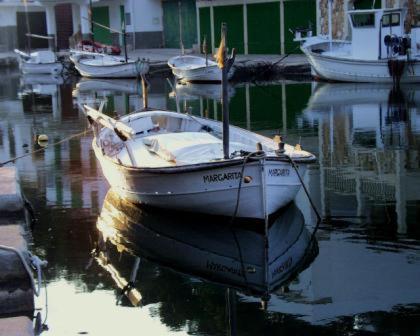 a boat sitting in the water in a harbor at Apartamento Jordi in Cala Figuera