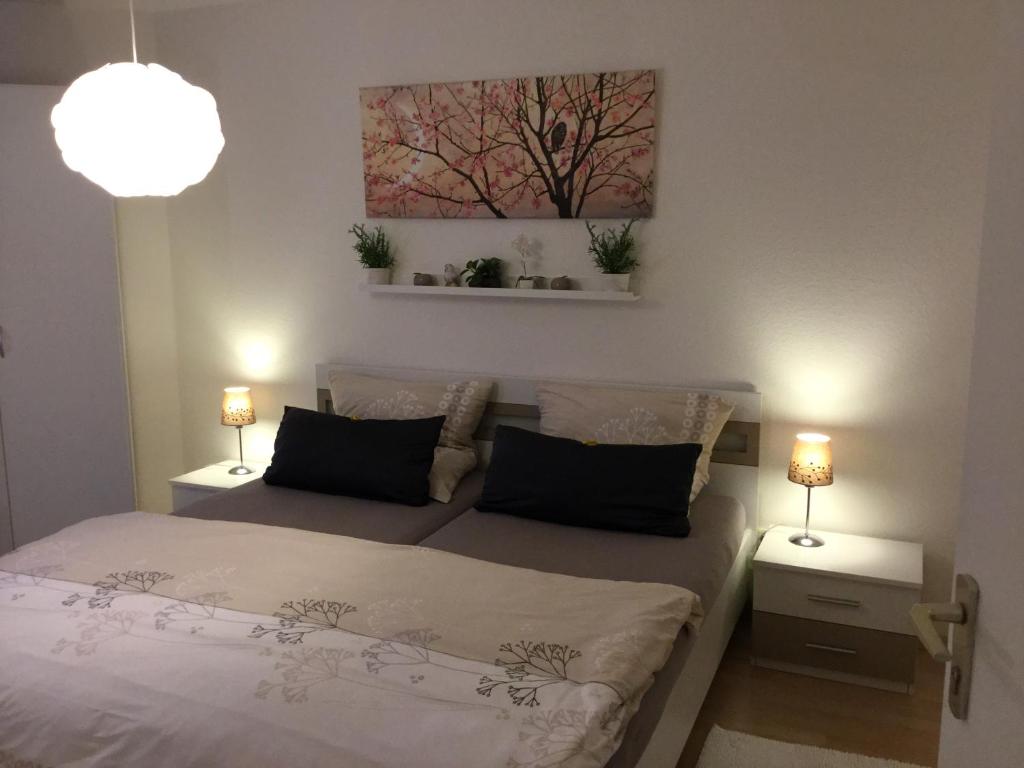 a bedroom with a bed and two lamps and a painting at Fewo Bella Margitta Baumann in Stegen