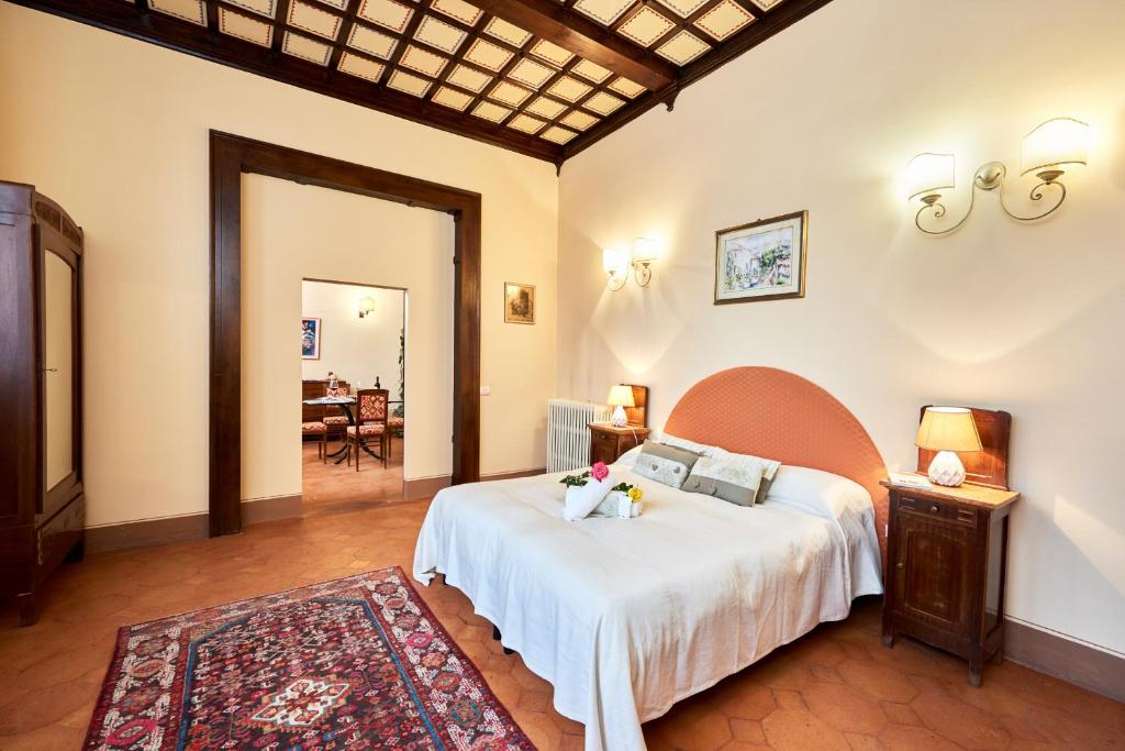 Un dormitorio con una gran cama blanca y una mesa en Villa Socini, en Siena