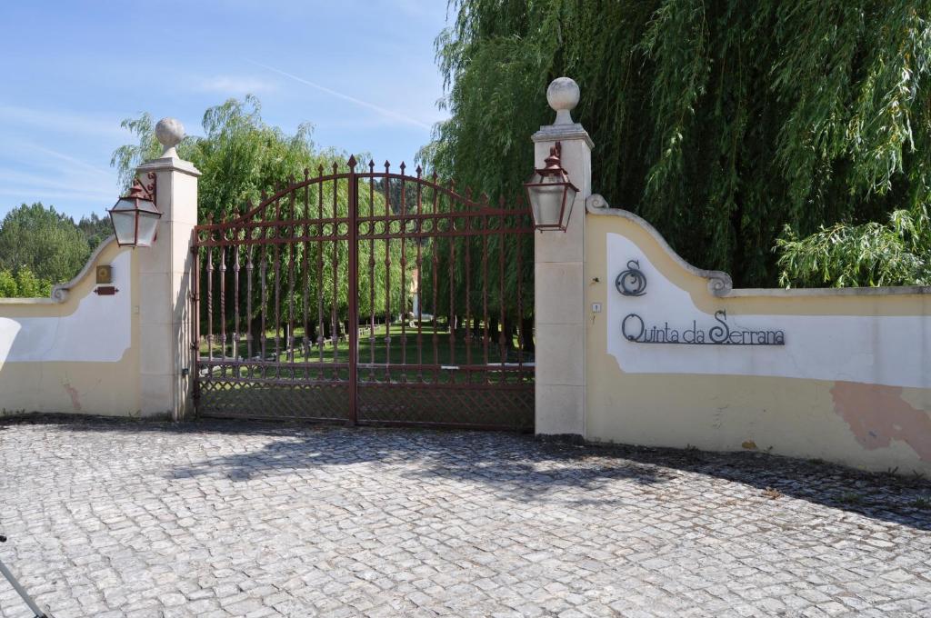 a gate to a driveway in front of a house at Quinta da Serrana in Ourém