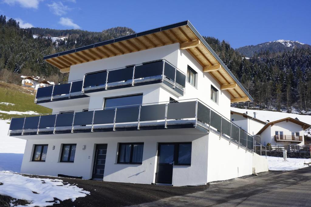 a white building with solar panels on it at Apartment Hanna in Ramsau im Zillertal