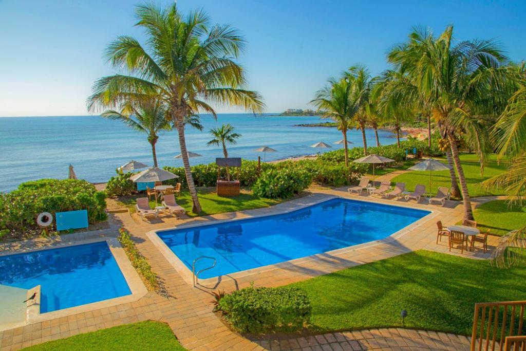 an aerial view of a resort pool and the ocean at Las Villas Akumal in Akumal