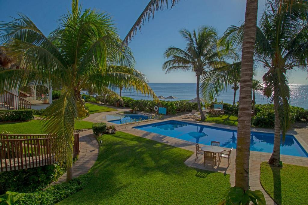 an aerial view of a resort with a swimming pool and the ocean at Las Villas Akumal in Akumal