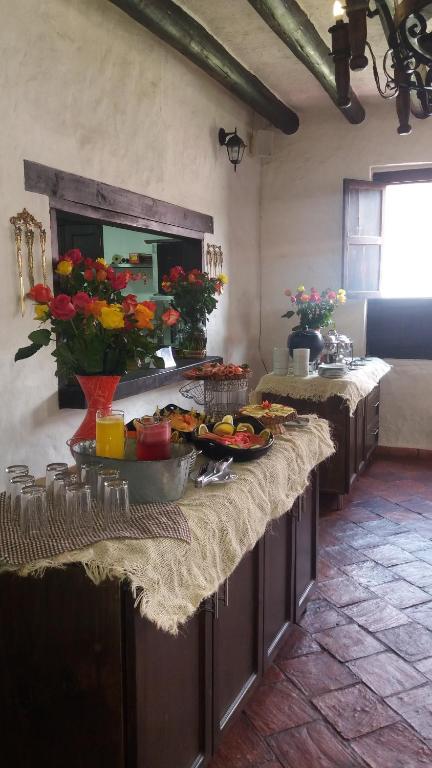 a kitchen with a table with food and flowers at Casona Quesada in Suesca