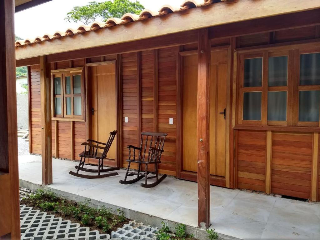 a screened in porch with two chairs and a table at Pousada da Praia II in Guarujá